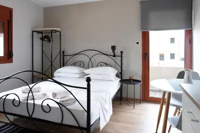 a bedroom with a black metal bed with white pillows at The Suite Spot - At The Heart Of The Old Town in Chania Town
