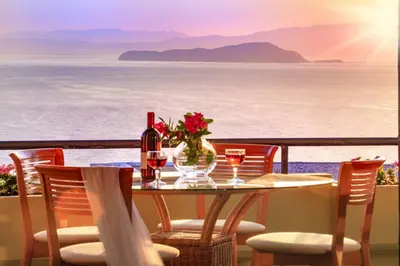 a table with wine glasses and a vase with flowers at Koralia - Chanias Card Postal Villa Majestic View in Chania Town