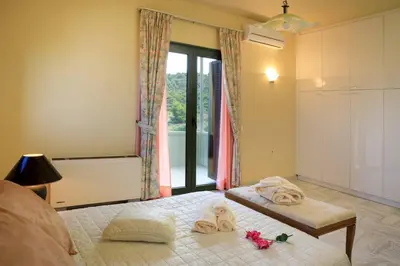 a bedroom with a bed with towels and a window at Koralia - Chanias Card Postal Villa Majestic View in Chania Town