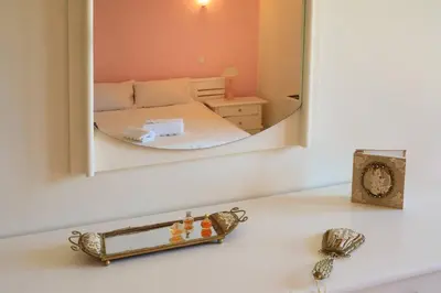 a mirror over a white counter with a bed in a room at Koralia - Chanias Card Postal Villa Majestic View in Chania Town