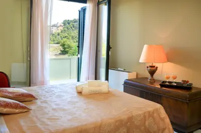 a bedroom with a bed with a window and a lamp at Koralia - Chanias Card Postal Villa Majestic View in Chania Town