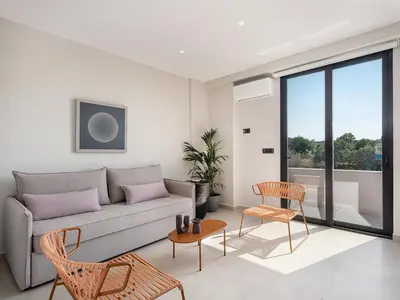 a living room with a couch and a table and chairs at Theta Boutique Hotel in Chania Town