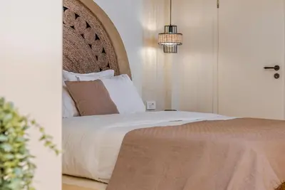 a bedroom with a bed and a chandelier at Disegno Villa - Rooftop Pool in Kolymvari
