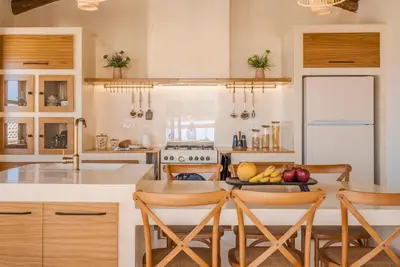a kitchen with a table with a plate of fruit on it at Disegno Villa - Rooftop Pool in Kolymvari