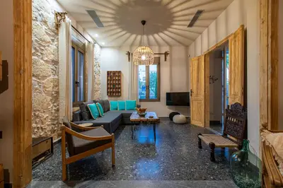 a living room with a couch and chairs and a chandelier at Casa di Batsi in Chania Town