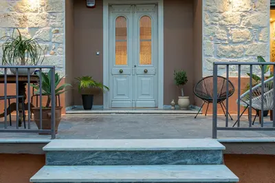 a front door of a house with chairs and a table at Casa di Batsi in Chania Town