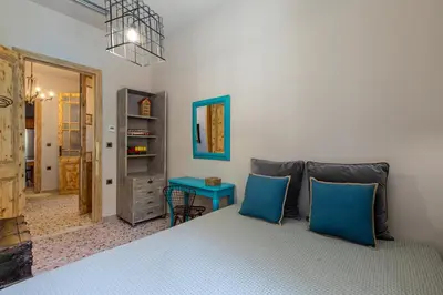 a bedroom with a bed with blue pillows at Casa di Batsi in Chania Town