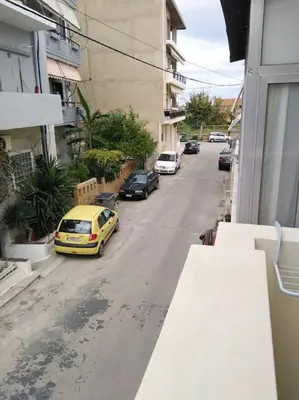a yellow car driving down a street with parked cars at Leli House in Chania Town