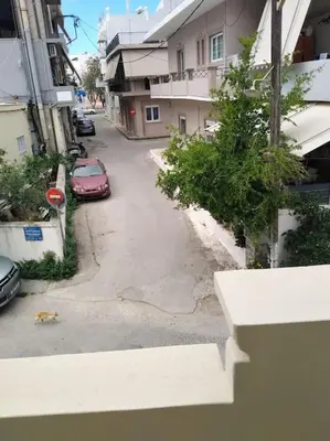an empty street with a red car parked next to buildings at Leli House in Chania Town