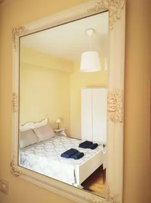 a mirror reflecting a bedroom with a bed in it at Leli House in Chania Town