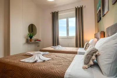 a bedroom with two beds with towels on them at Armeria Apartments in Daratso