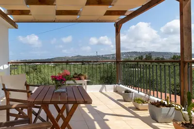 a patio with a table and chairs on a balcony at Eliva house in Chania Town