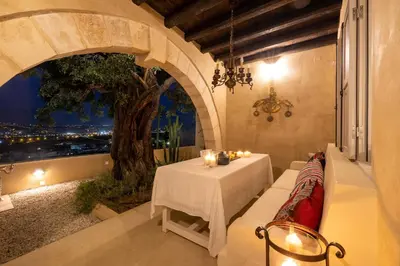 a dining room with a table and a tree at Rimondi Residences Chania in Chania Town