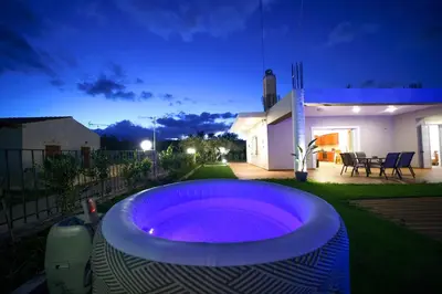 a large hot tub in the yard of a house at Villa Lima Pool & Jacuzzi Chania in Vamos