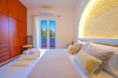 a bedroom with a large bed with towels on it at Villa Lima Pool & Jacuzzi Chania in Vamos