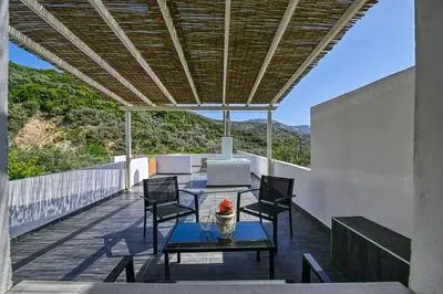 a patio with a table and chairs on a roof at Haroto Home Residence in Plokamianá