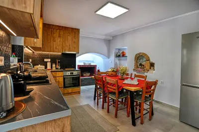 a kitchen with a red table and chairs at Haroto Home Residence in Plokamianá