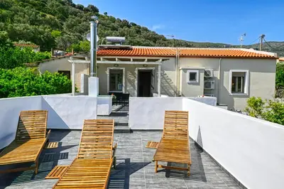 a group of chairs sitting on a patio with a house at Haroto Home Residence in Plokamianá