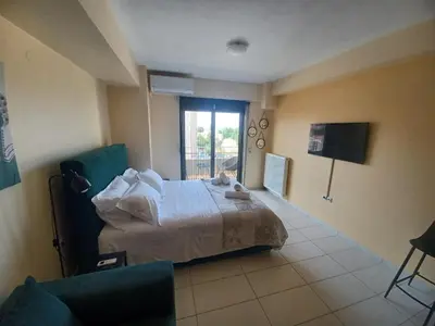 a bedroom with a bed and a tv and a couch at City Spot Chania in Chania Town