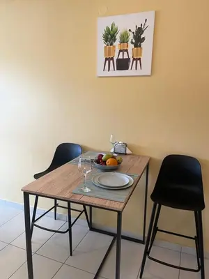 a table with chairs and a bowl of fruit on it at City Spot Chania in Chania Town