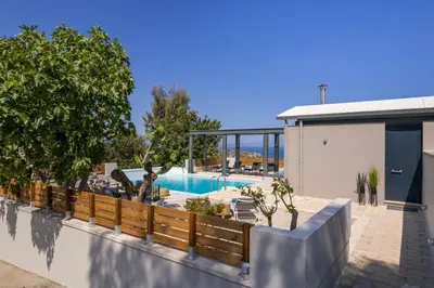 a house with a swimming pool and a fence at Natura Hill Villa IV Sea View in Kounoupidhianá