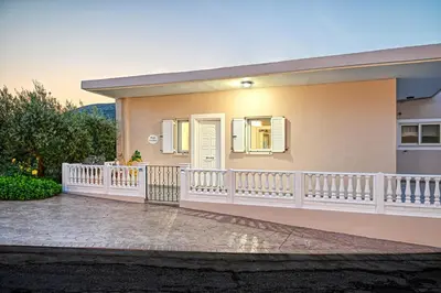 a house with a white fence and a balcony at Hope apt - 5min to Falassarna Bch in Kissamos