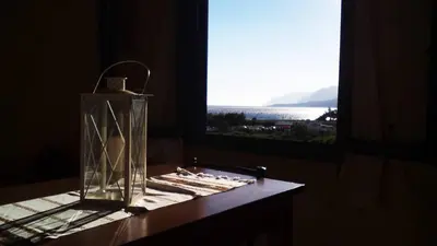 a glass vase sitting on a table next to a window at Vrachos Apartments in Frangokastello