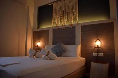 a bedroom with a bed with two lights on it at Pasithea in Frangokastello