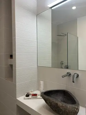 a bathroom with a stone sink and a mirror at Camelia Home in Chania Town