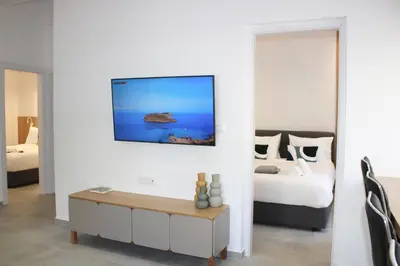 a bedroom with a bed and a tv on a wall at Camelia Home in Chania Town