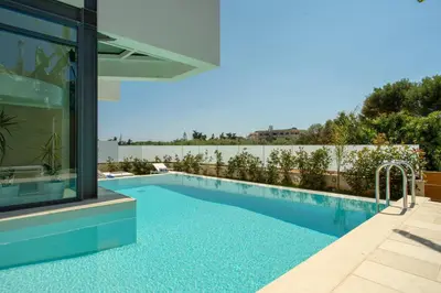 a swimming pool with a view of a house at Luxury Villa Mirror - 200meters From The Beach in Daratso