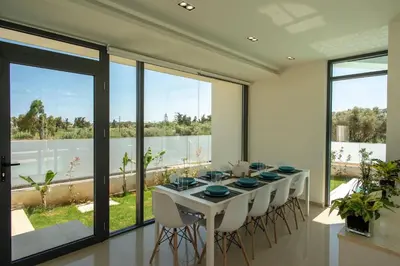 a dining room with a white table and chairs at Luxury Villa Mirror - 200meters From The Beach in Daratso