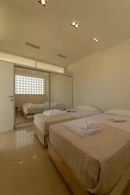 a bedroom with two beds and a large mirror at Luxury Villa Mirror - 200meters From The Beach in Daratso