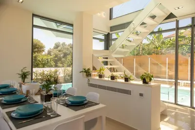 a dining room with a table and chairs and large windows at Luxury Villa Mirror - 200meters From The Beach in Daratso