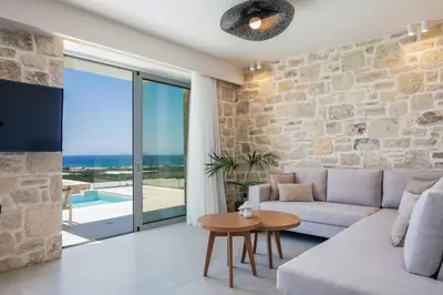 a living room with a couch and a table at Petras Luxury Villas in Falasarna