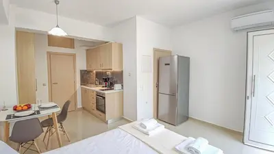 a kitchen with a stainless steel refrigerator and a table at Fully renovated Studio in Platanias in Plataniás