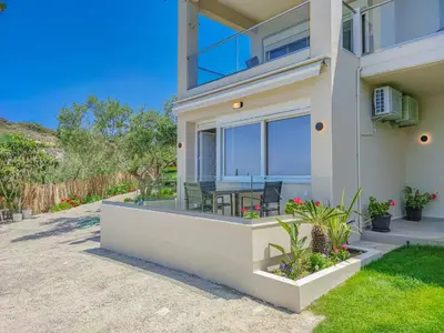 a house with a balcony with a table and chairs at Fully renovated apartment in Platanias 1 in Plataniás