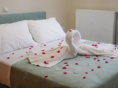 a bed with white sheets and red flowers on it at Giovanni City House near Chania City Center in Chania Town