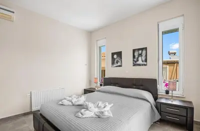 a bedroom with a bed with white towels on it at Villa Blue Dreams in Maleme in Ayiá