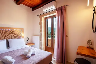 a bedroom with a bed with two towels on it at Kotinos Luxury Villa in Chania Town