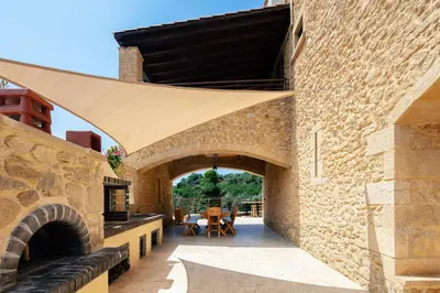 a stone building with awning over a patio at Kotinos Luxury Villa in Chania Town