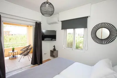 a bedroom with a bed and a mirror at Villa Per Mare in Maleme
