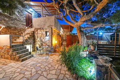 a stone patio with a tree and stairs at PefkoPetro Loft in Chania Town