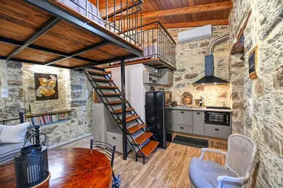 a kitchen with a spiral staircase and a table at PefkoPetro Loft in Chania Town