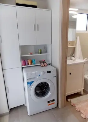 a washer and dryer in a kitchen with a cabinet at Alena home in Chania Town