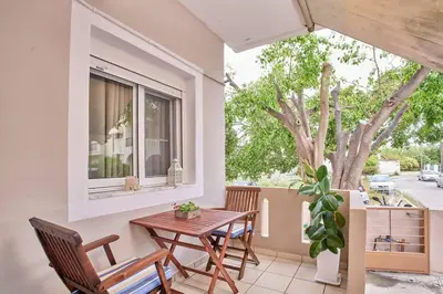 a patio with a table and chairs and a window at Lux and Cozy in Kato Daratso