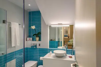 a bathroom with a sink and a toilet and blue tiles at Studios Rika in Plataniás