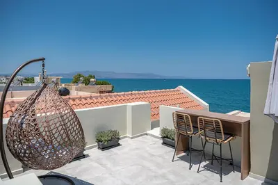 a balcony with a table and chairs and the ocean at Lavender suite sea view in Plataniás