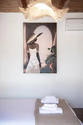 a painting of a woman with a hat on a wall at Lavender suite sea view in Plataniás