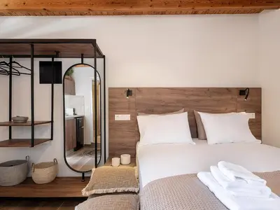 a bedroom with a large white bed and a mirror at Lavender suite sea view in Plataniás